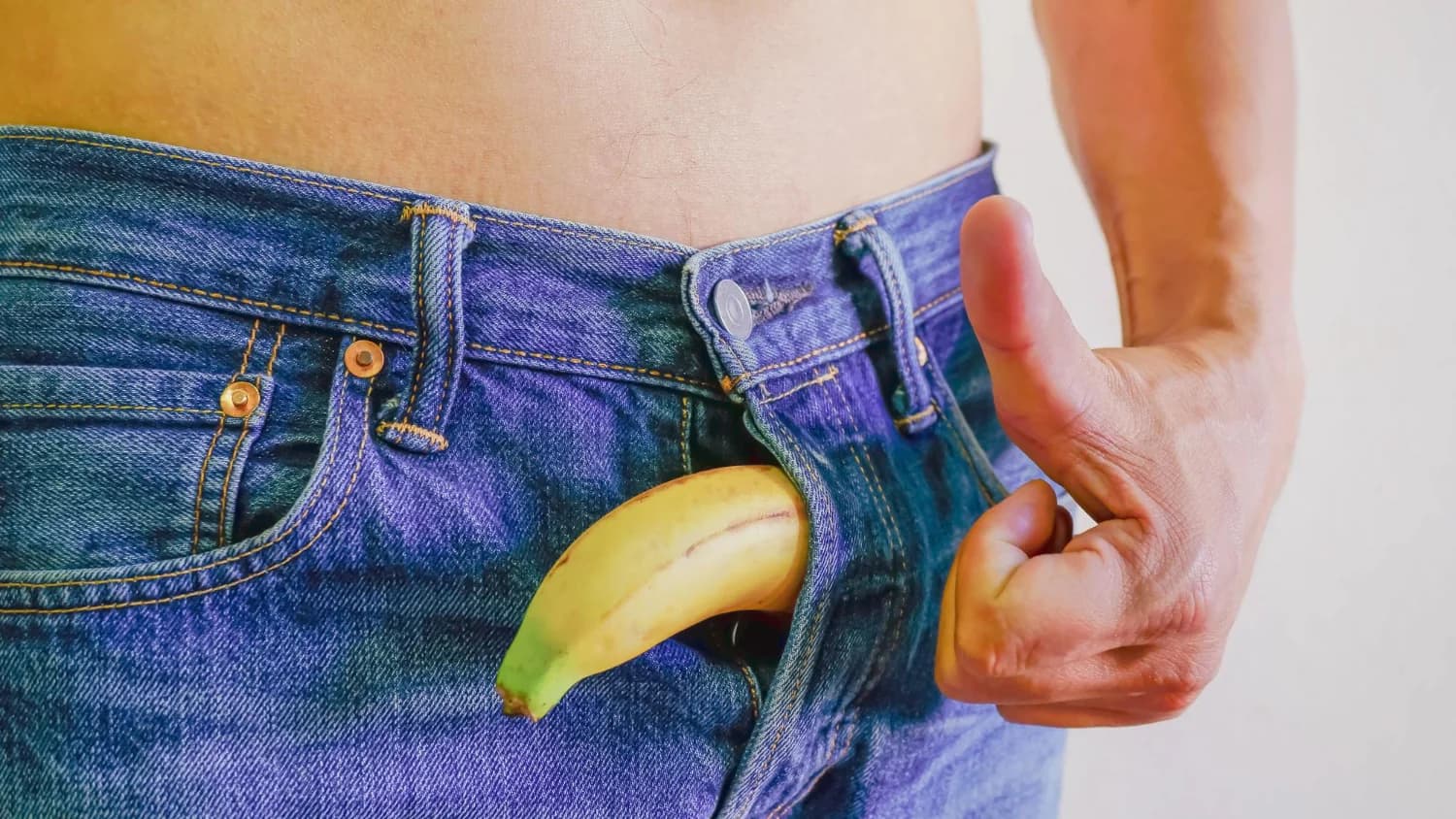 Plátano sostenido con una mano como metáfora visual de la salud sexual masculina